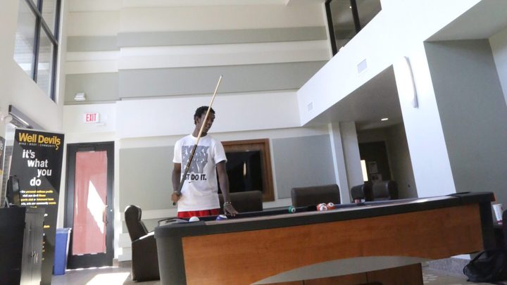 An ASU student playing pool in a ASU dorm