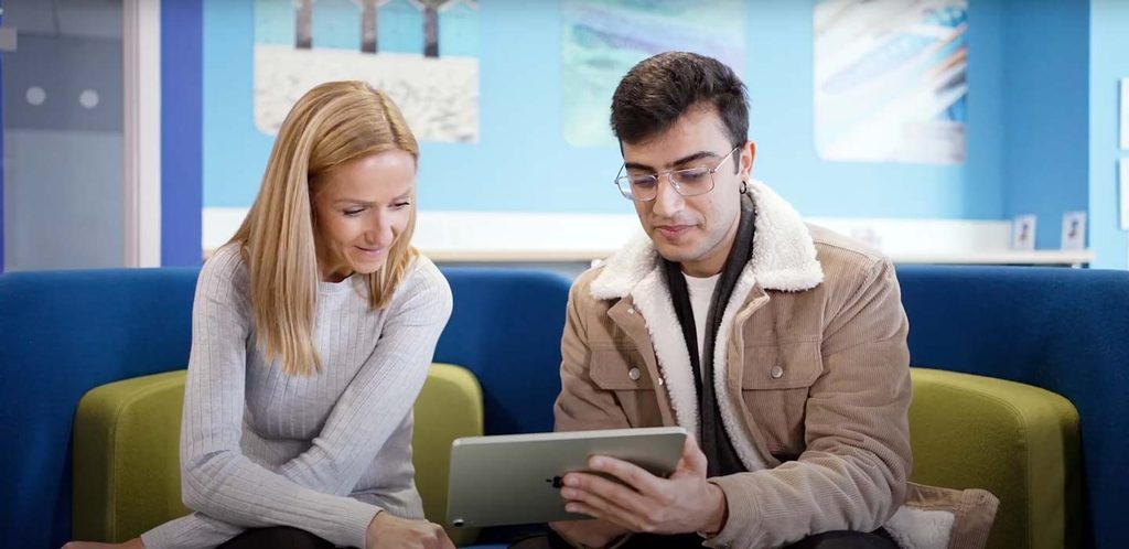 Student and tutor looking at an iPad together studying tutorial