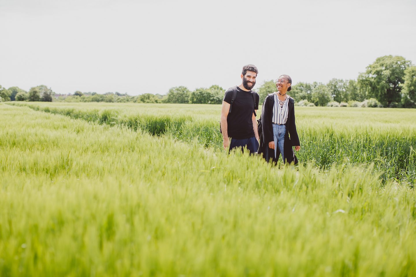 Students with smiling faces having a walk in green grass field