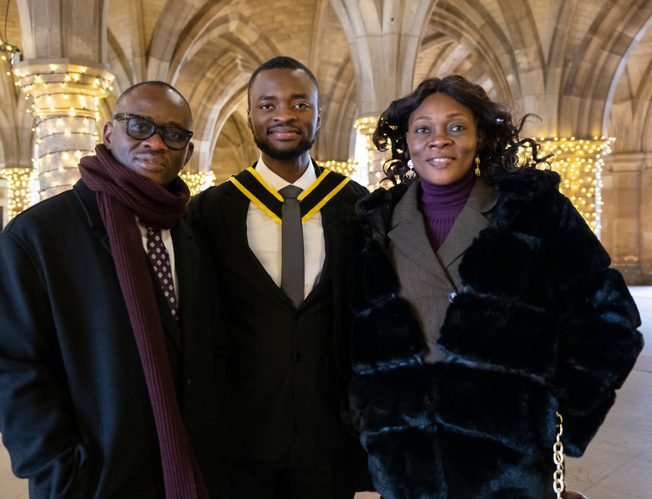 Kayode, a Glasgow student, posing with his parents on graduation day