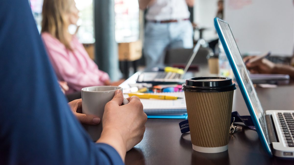 a Kaplan employee having a cup of tea during a meeting