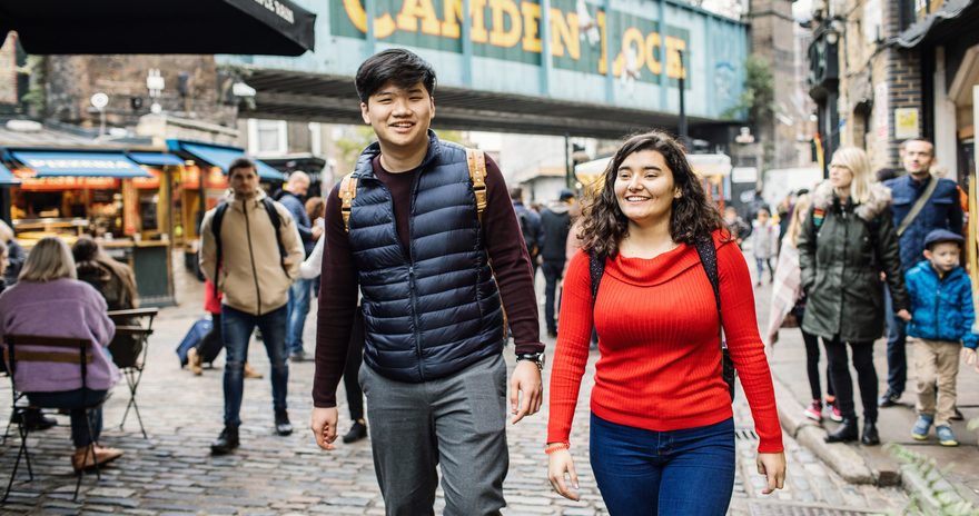Two students with smiling faces walking around Camden