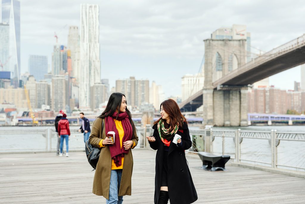 Two Pace University walking and having a coffee bankside