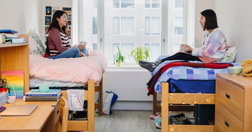 Two students having a tea on their beds in Pace University's student housing