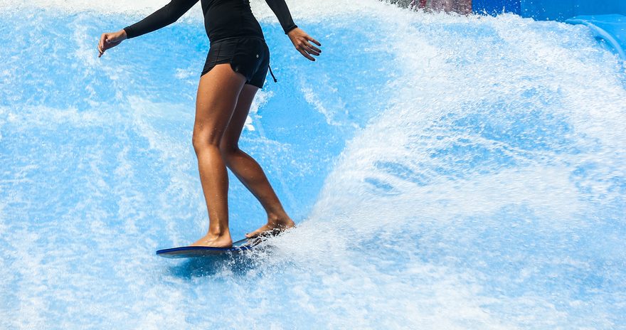 Student surfing on wave pool