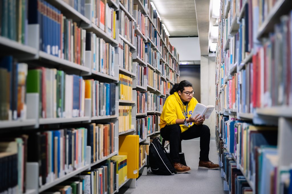 A student reading a book in the library