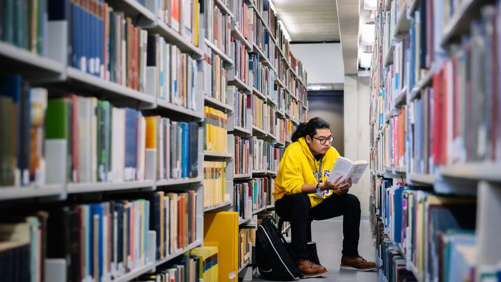 A student reading a book in the library