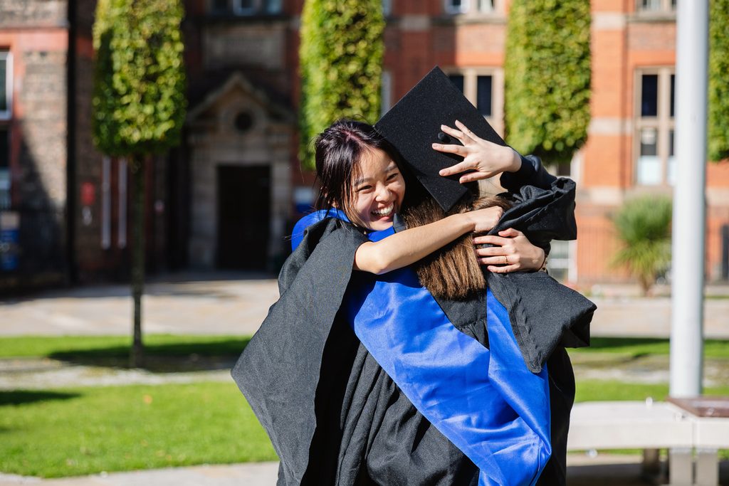 Two UoLIC students hugging on graduation day
