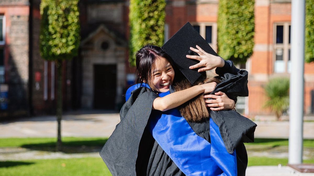 Two UoLIC students hugging on graduation day