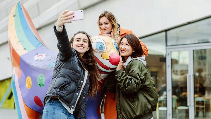 Liverpool College students taking a selfie with a statue