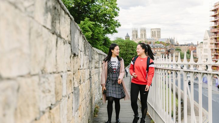 Students walking in york city with York Minster behind