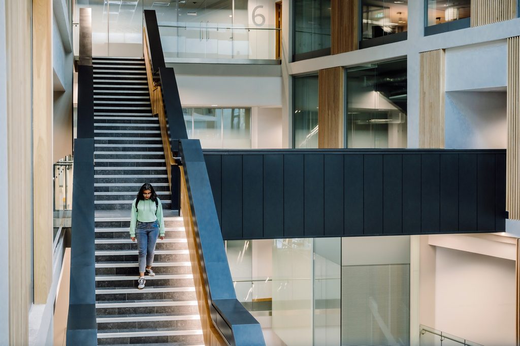 Student walking down the stairs inside the building