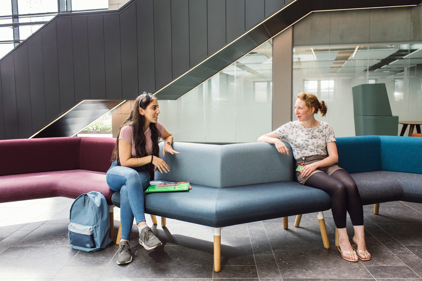 Student talking to a teacher inside building