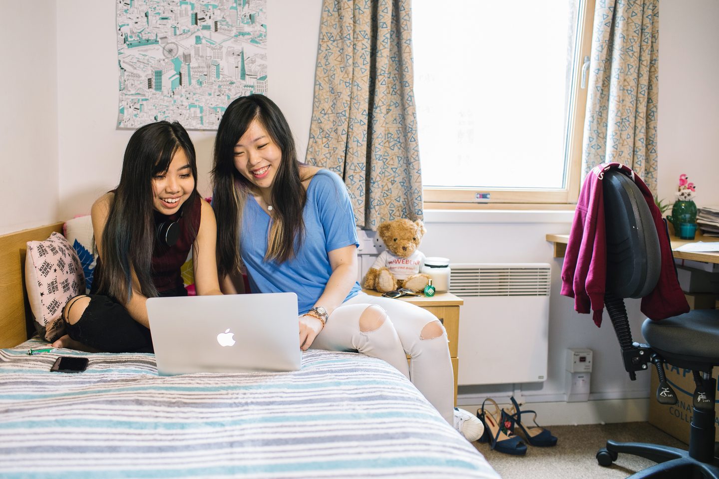 Students looking at a laptop on the bed