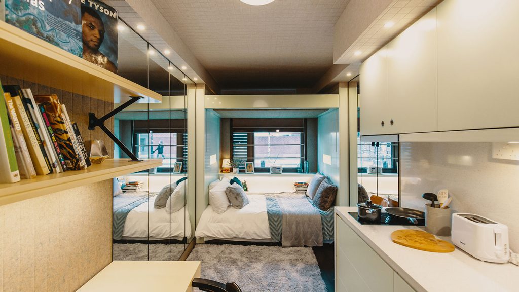 a studio room at the stay club kentish town in london with a kitchenette, study desk and a bed