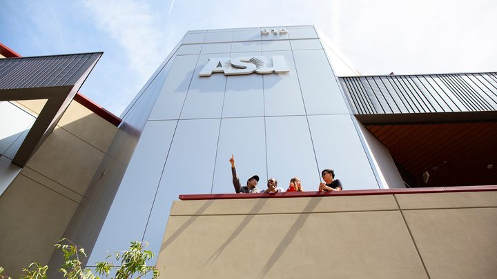Students below the ASU sign pointing