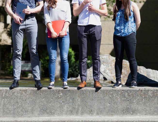 Legs of students on the fountain.