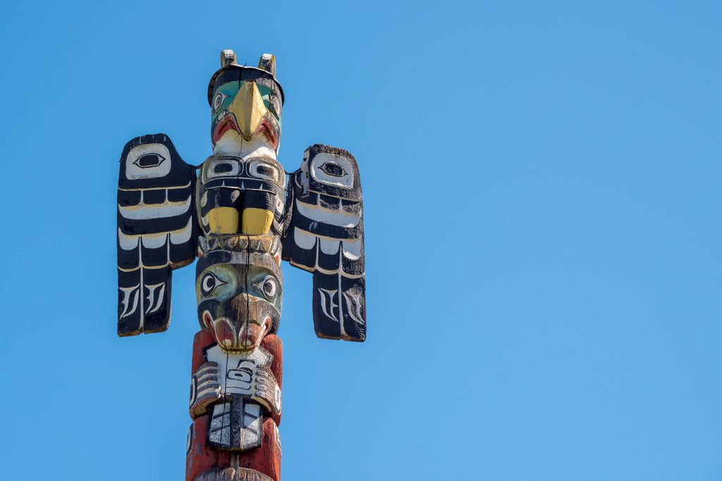 Tall wood carved Totem pole on Vancouver Island, British Columbia, Canada.